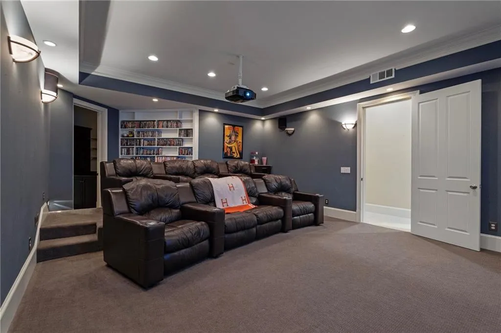 Carpeted cinema room featuring crown molding, recessed lighting, a raised ceiling, and built in features