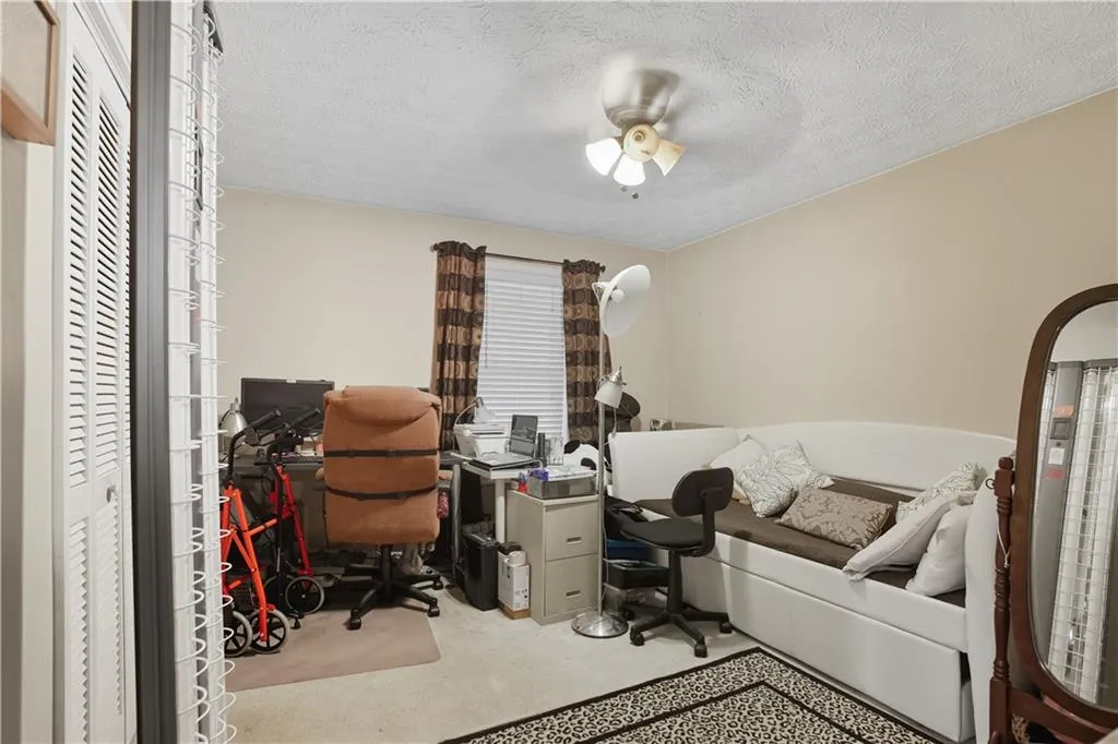 Office area with a textured ceiling and a ceiling fan