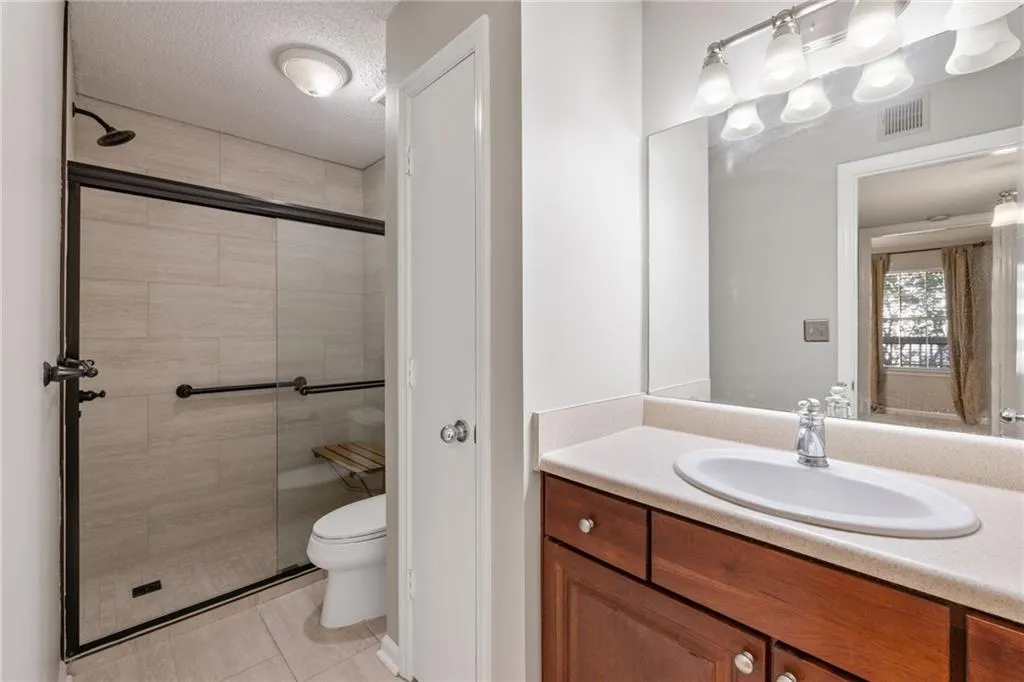 Walk-in shower with tile surround and black-framed glass enclosure