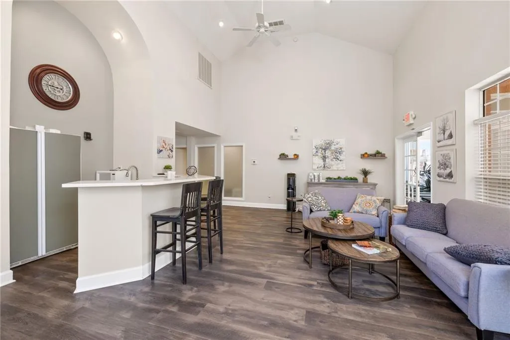 Spacious interior featuring a vaulted ceiling, wood-finish flooring, and a white ceiling fan