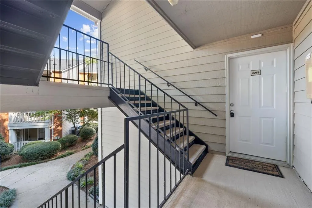 Modern entryway featuring a striking black metal staircase with horizontal railings, light wood-finish horizontal shiplap walls, and a white six-panel entry door with sidelights