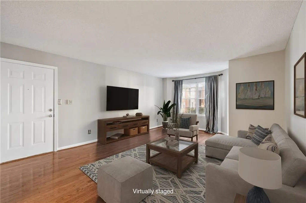 Hardwood-finish flooring, light-toned wall paint, white trim, and a window with white blinds