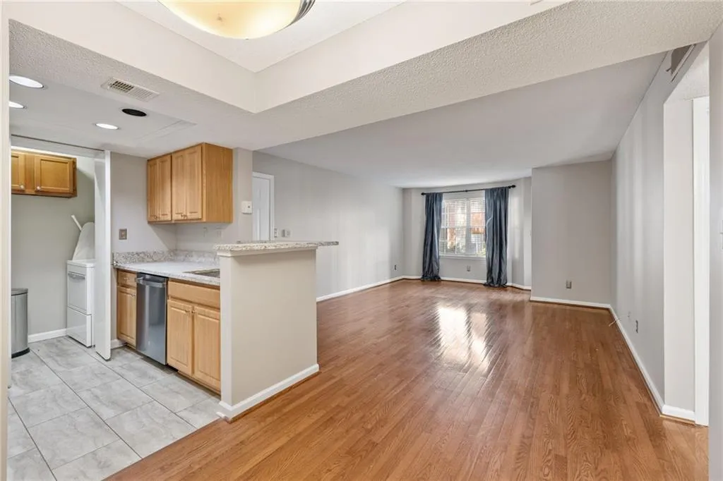 Open-concept layout with wood-finish flooring, recessed lighting, and a breakfast bar
