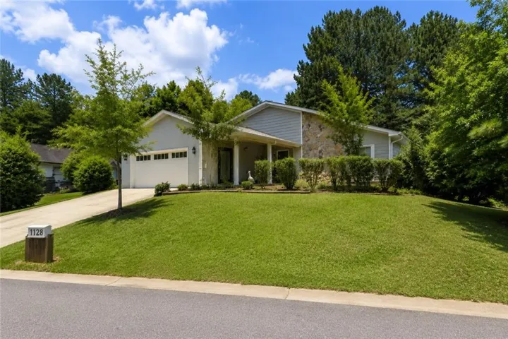 Contemporary exterior featuring a stone and siding facade, a two-car garage, a concrete driveway, and a covered entry