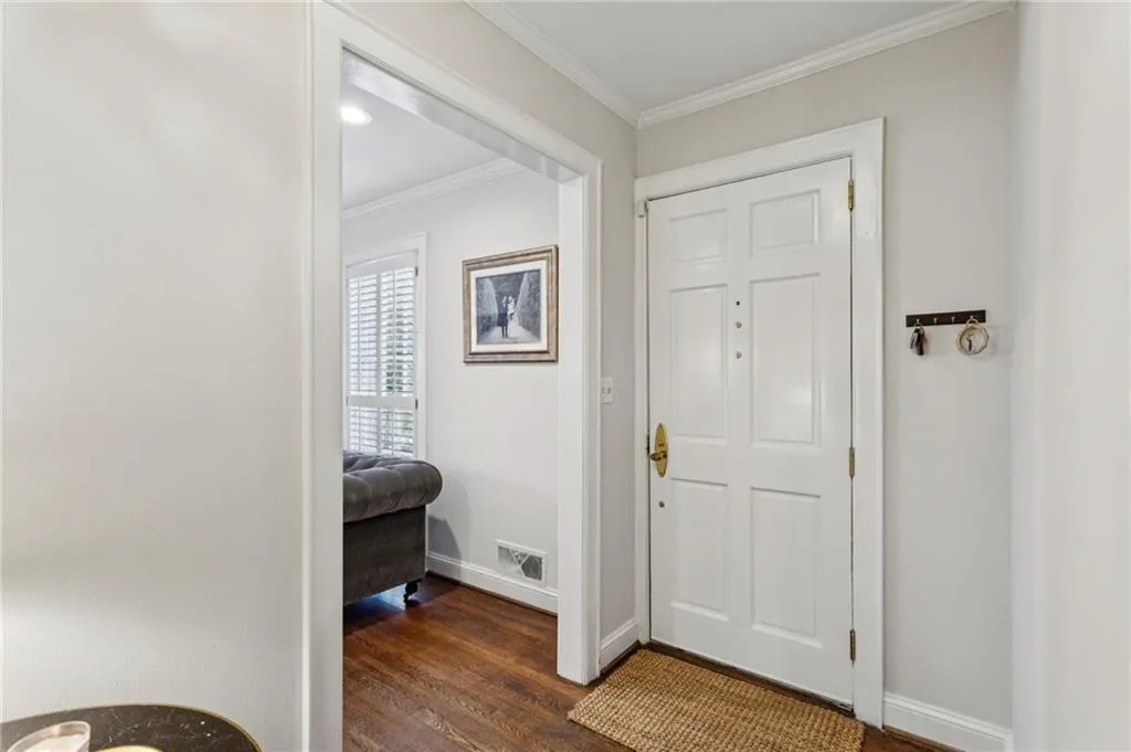 Foyer entrance featuring ornamental molding and dark wood-style floors