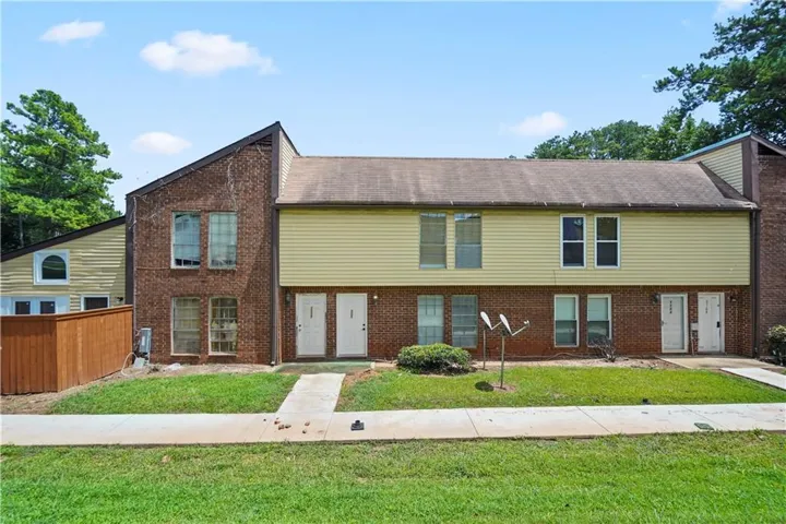 Brick and siding exterior with multiple entry doors and a sloped roofline