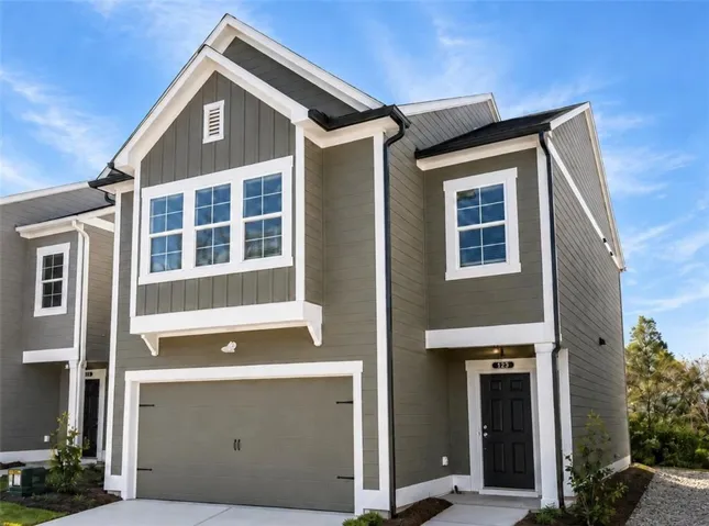Modern townhome exterior with olive green siding and white trim