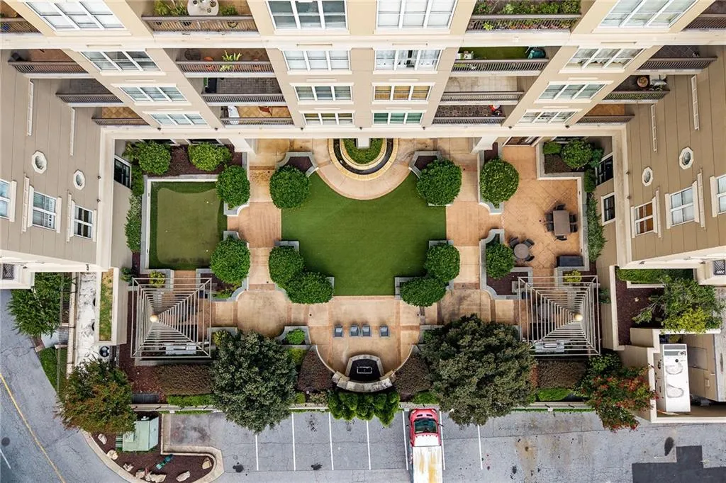 Central courtyard with a manicured lawn, paver stone pathways, a putting green, and mature plantings