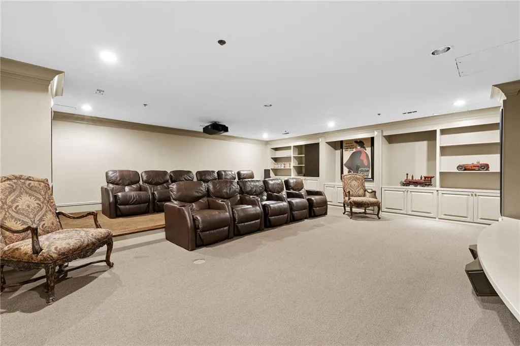 Recessed lighting, wall-mounted projector, built-in shelving, built-in cabinetry, and carpeted flooring