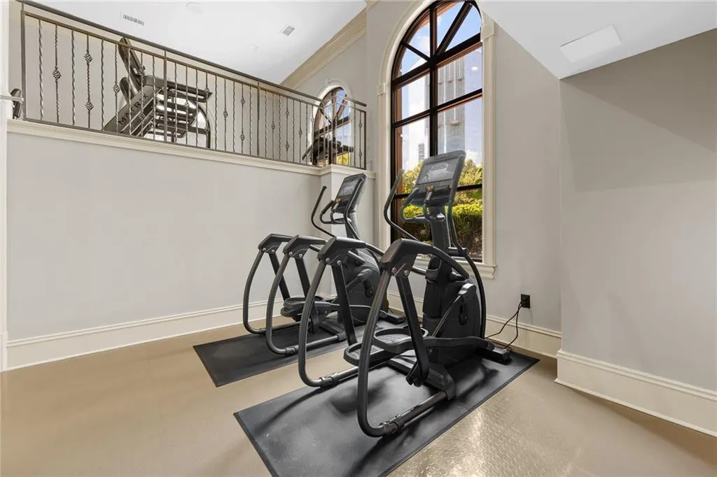 Arched windows, wrought iron railing, and neutral wall finishes