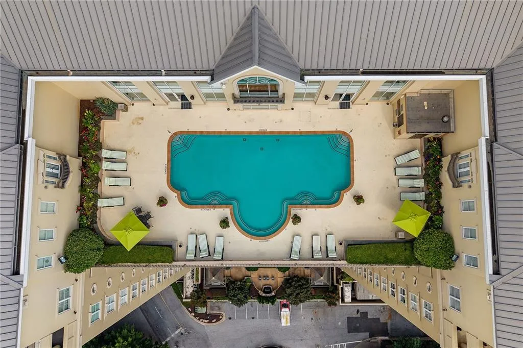 Courtyard with a swimming pool, surrounding patio, and planted garden beds