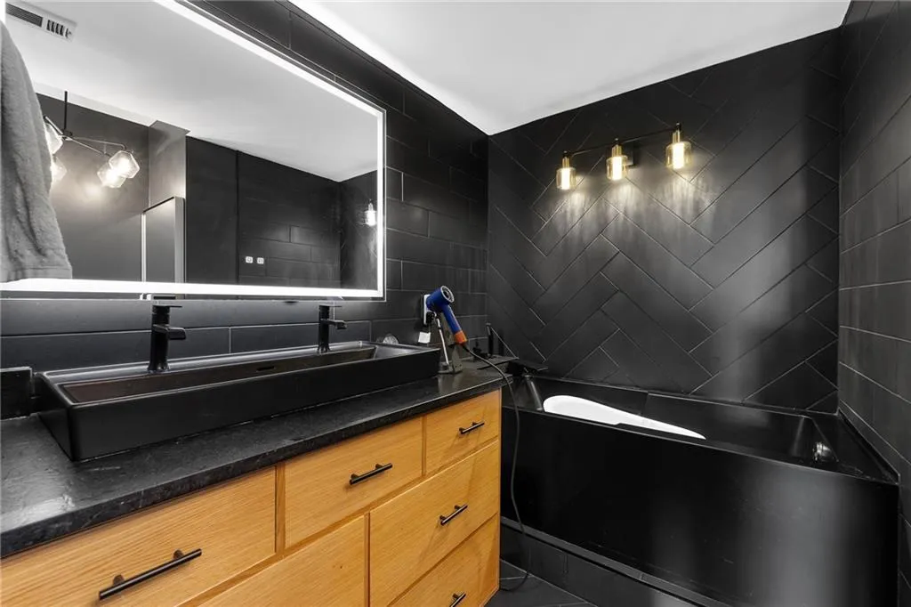 Double vanity with matte black vessel sink and faucets