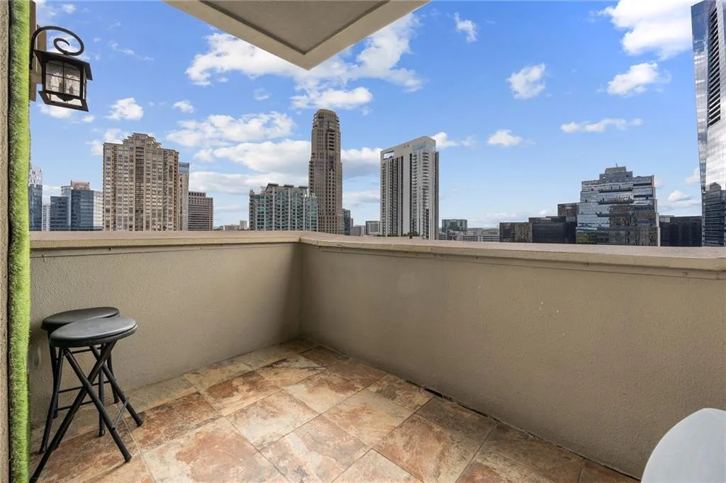 Balcony with tiled flooring, sconce lighting, and cityscape scenery
