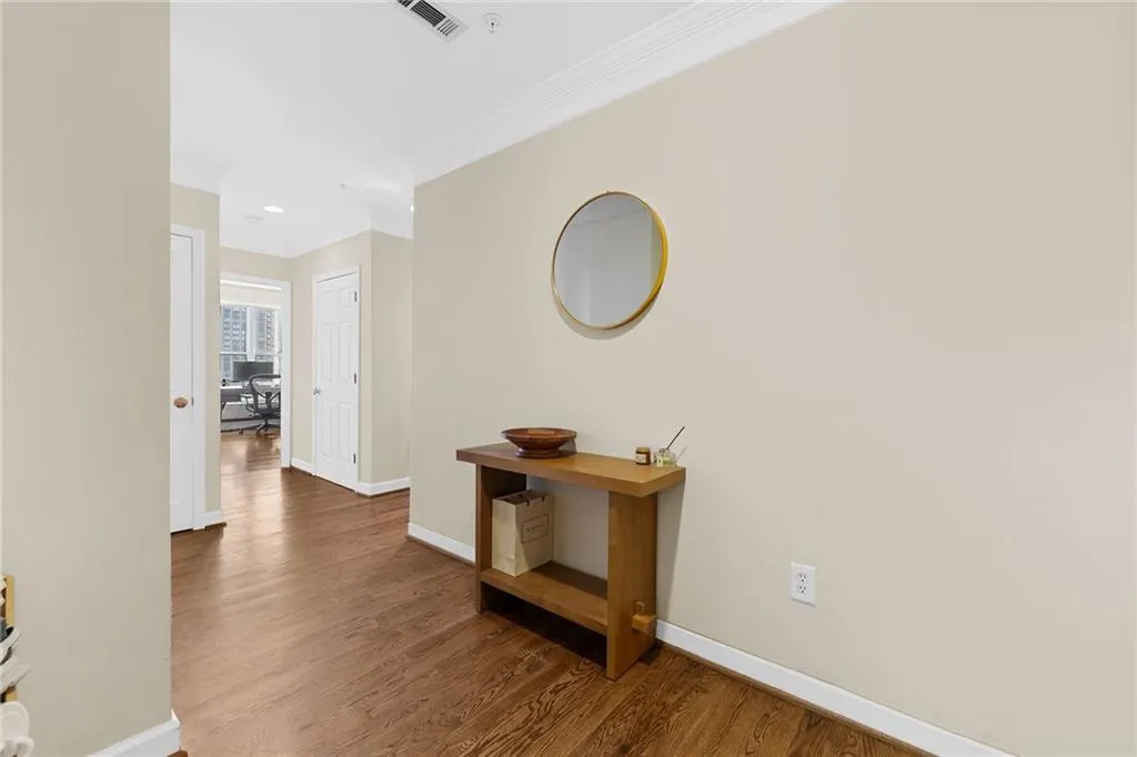 Hardwood-style flooring throughout, crown molding, and neutral wall tones