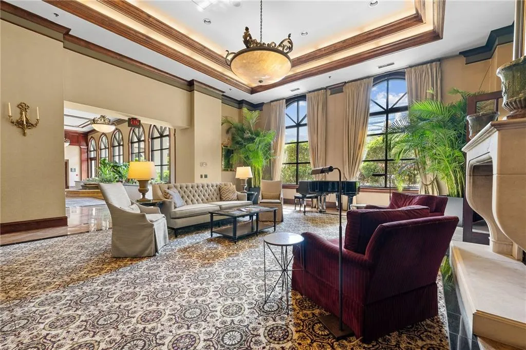 Grand communal space featuring a coffered ceiling, large arched windows, and an ornate chandelier