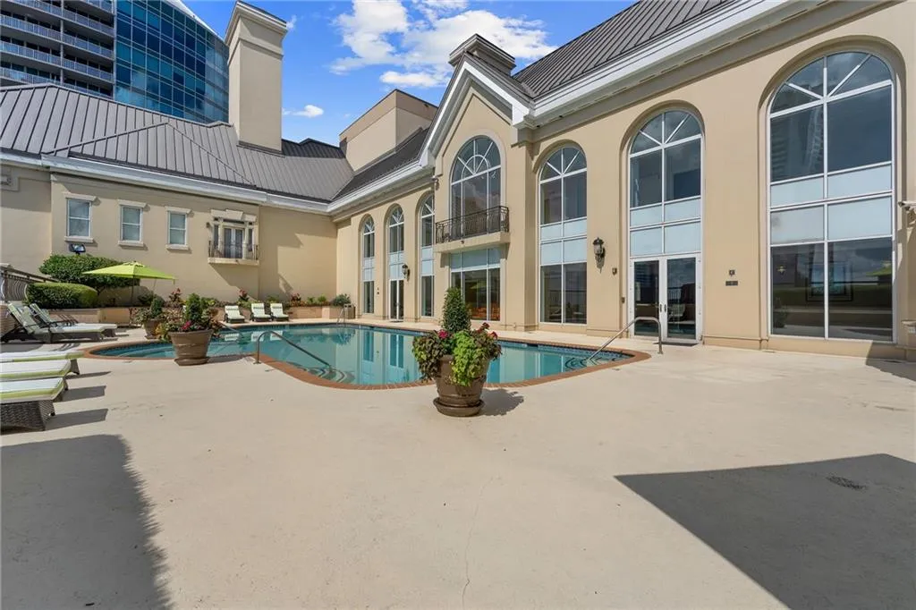 Expansive outdoor area featuring a swimming pool, integrated spa, and surrounding concrete patio