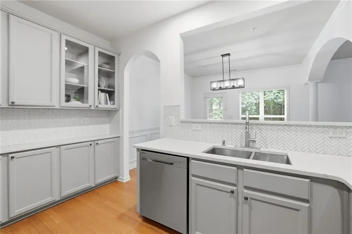 Modern kitchen featuring light gray cabinetry, a dual basin stainless steel sink, and a stainless steel dishwasher