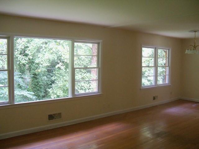 Unfurnished room featuring dark hardwood / wood-style flooring and an inviting chandelier