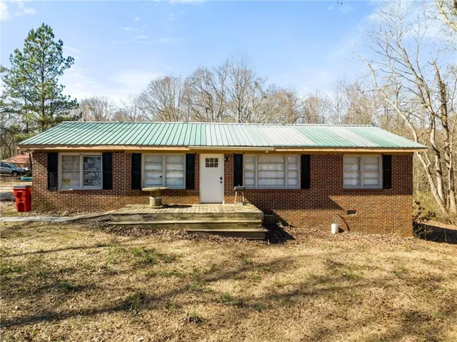 Ranch-style home featuring a front lawn