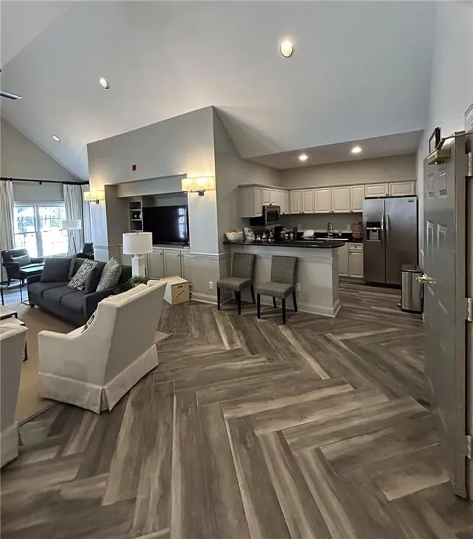 Living room with high vaulted ceiling and recessed lighting