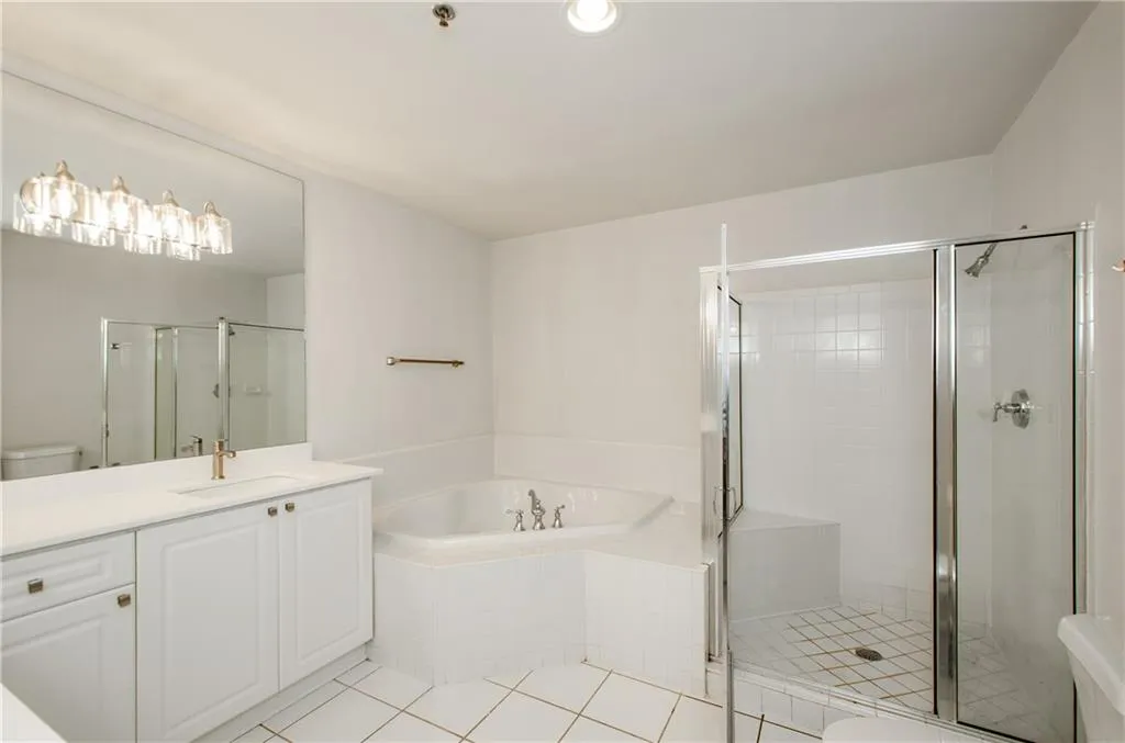 Full bathroom featuring toilet, a bath, vanity, a stall shower, and tile patterned flooring
