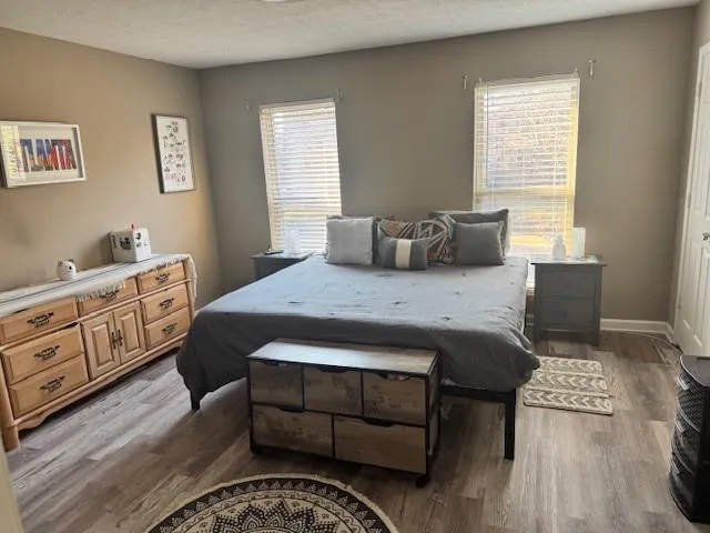 Bedroom with light wood-type flooring and a textured ceiling
