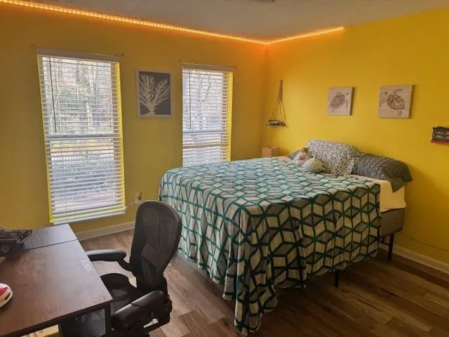 Bedroom featuring dark wood-style flooring and a desk