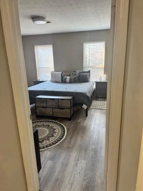 Bedroom featuring wood finished floors and a textured ceiling