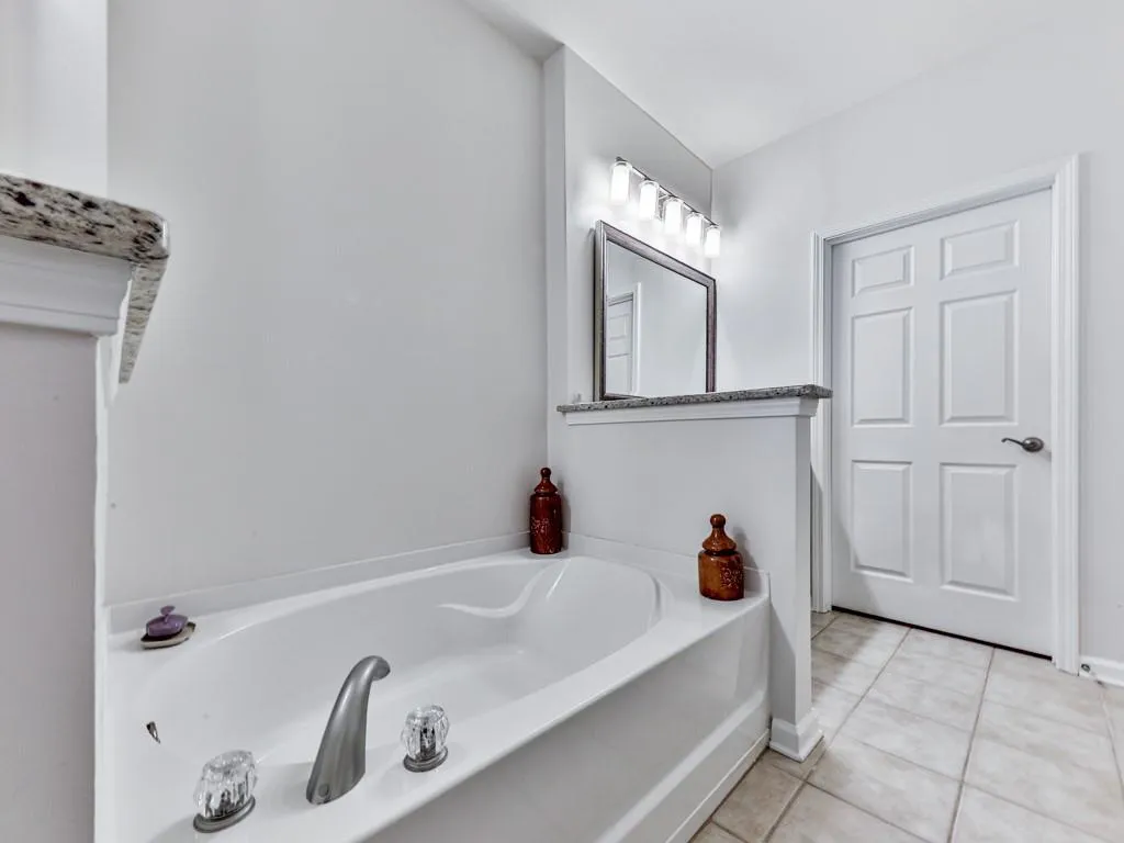 Full bathroom featuring tile patterned floors and a garden tub