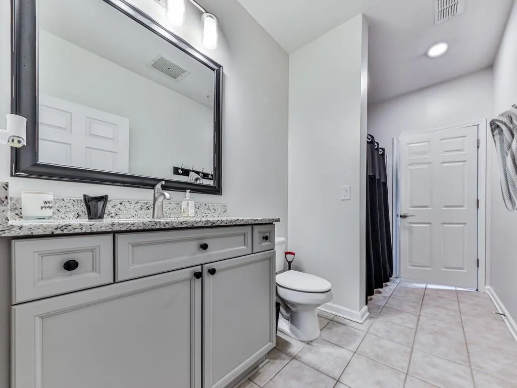 Full bath with tile patterned flooring, vanity, and a shower with shower curtain