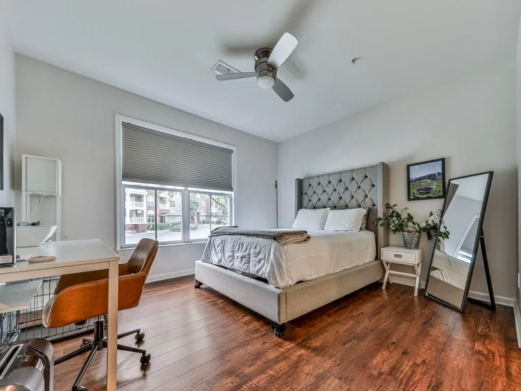 Bedroom featuring dark wood-type flooring, an office area, and ceiling fan