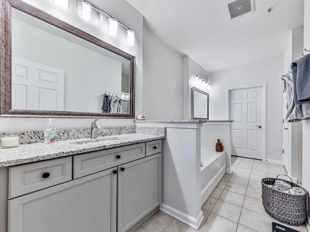 Full bath with vanity, tile patterned flooring, and a bath