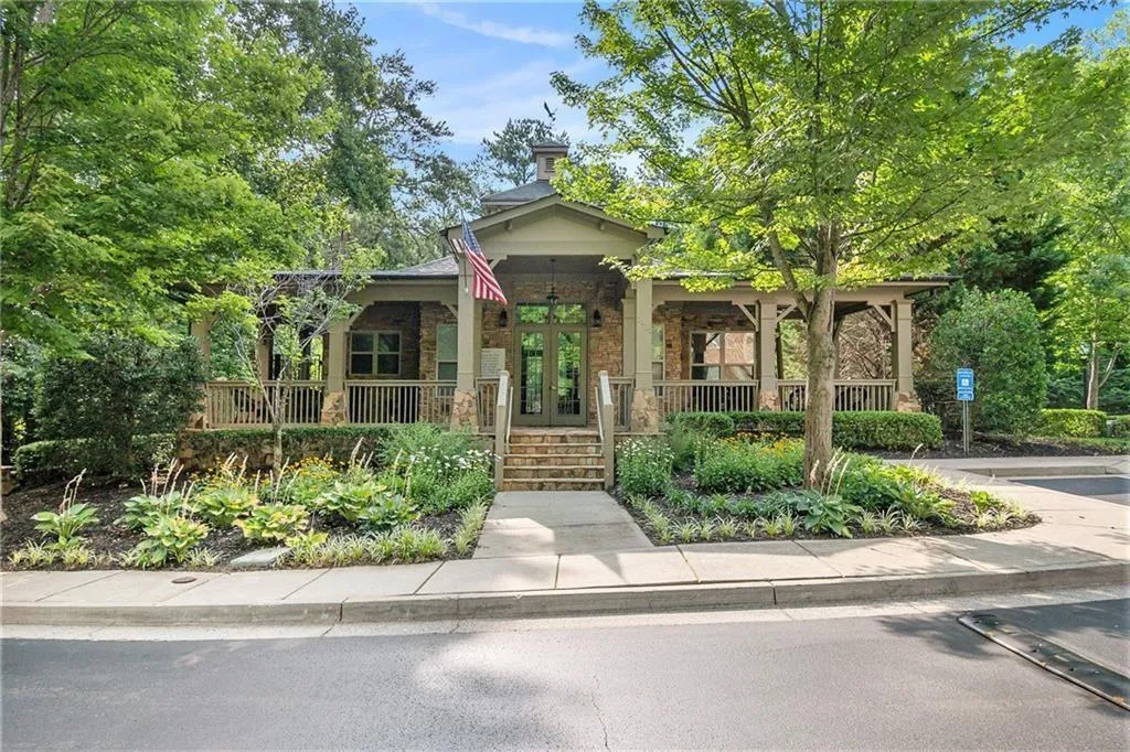View of front of property featuring french doors, a porch, brick siding, and a chimney