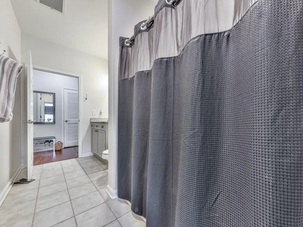 Full bathroom with tile patterned floors and a shower with curtain