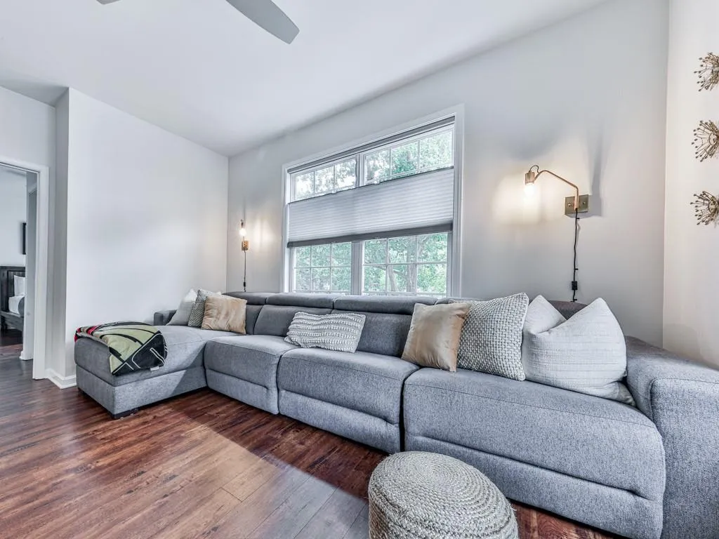 Living area with dark wood finished floors and ceiling fan