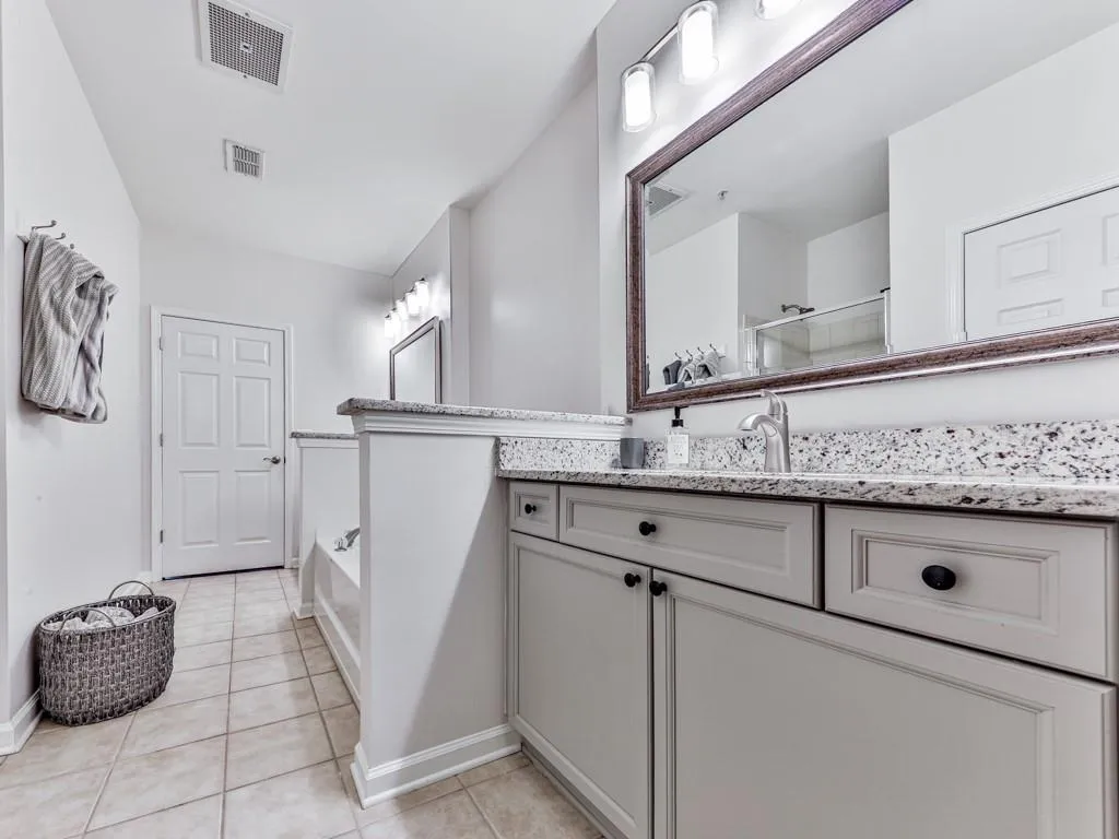Full bath featuring tile patterned floors, vanity, a bath, and a shower with shower door
