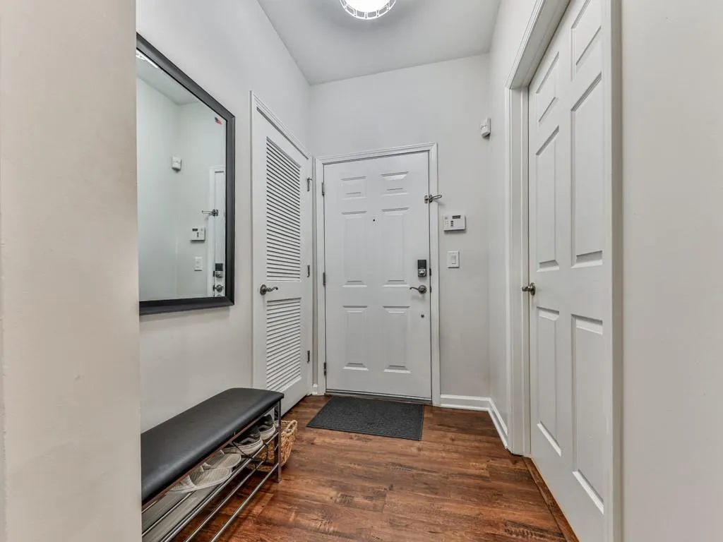 Doorway to outside with dark wood-style flooring and baseboards
