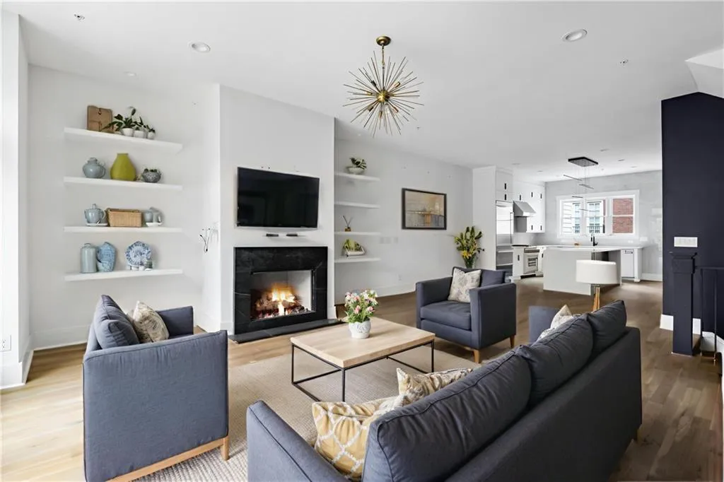 Living area with dark wood-style flooring, built in features, recessed lighting, and a tiled fireplace