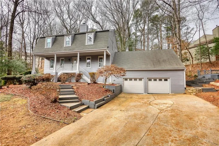 Traditional-style residence featuring light gray siding and a dormer window roofline