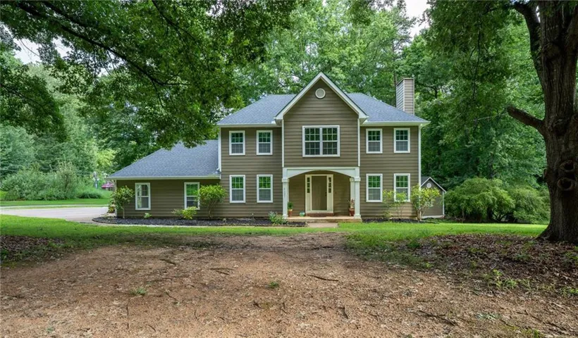 Two-story residence featuring a covered front entry, light green siding, and white trim