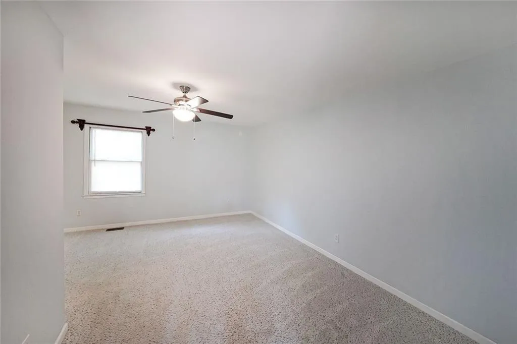 Spare room featuring a ceiling fan and baseboards