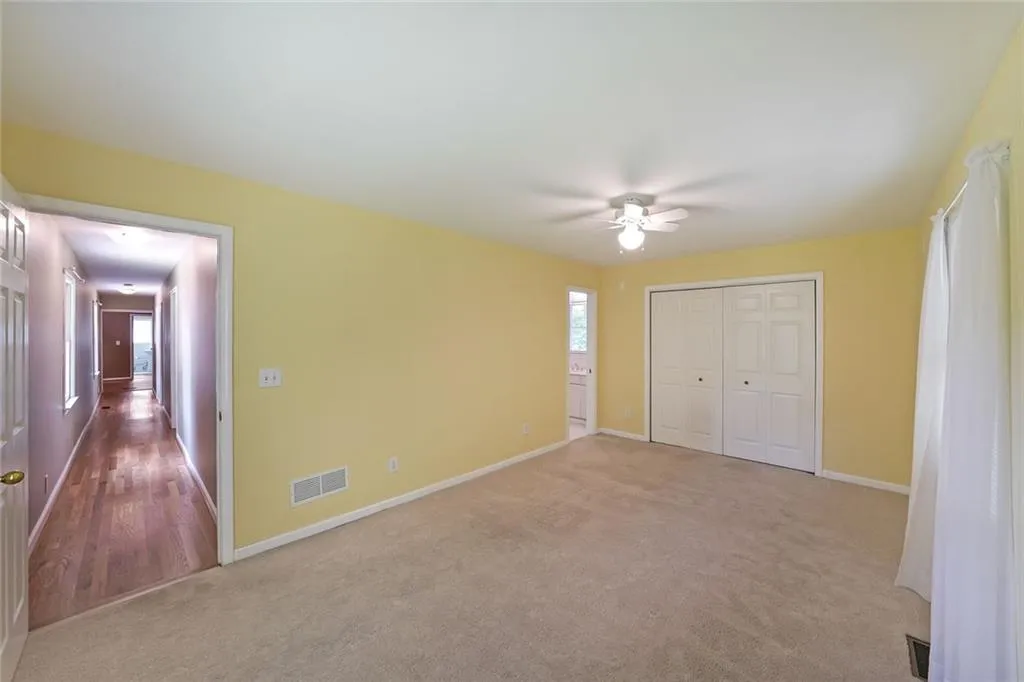 Unfurnished bedroom with carpet floors, multiple windows, baseboards, and a closet