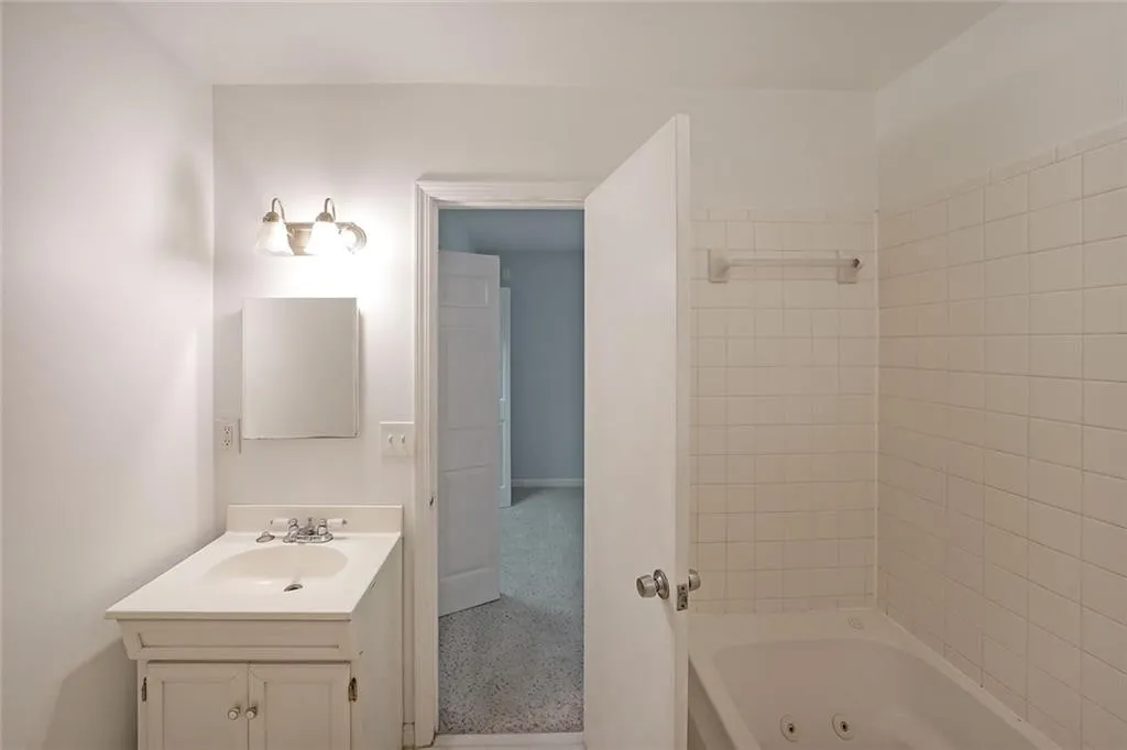 Full bathroom with vanity and a combined bath / shower with jetted tub