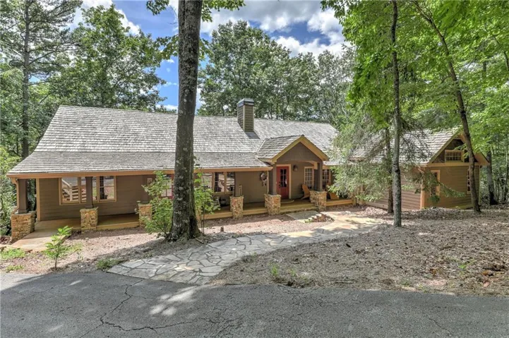 Rustic home featuring a chimney and a porch