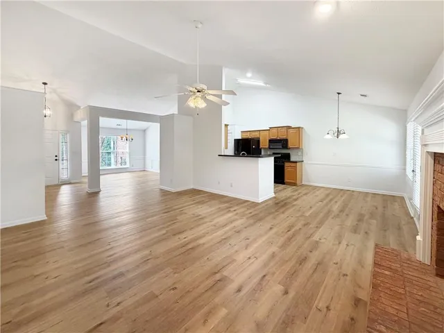Vaulted ceilings, wood-finish flooring, and a brick fireplace