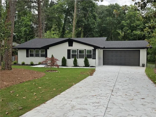 White brick exterior with black trim and a dark shingle roof