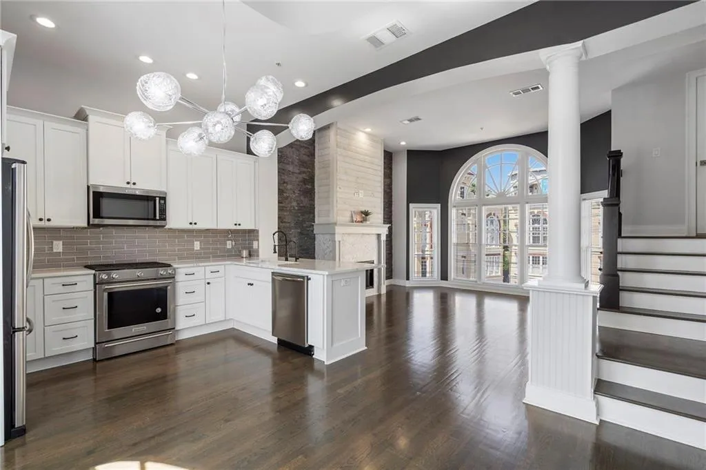 Kitchen with open floor plan, stainless steel appliances, white cabinets, a peninsula, and tasteful backsplash Kitchen with open floor plan, stainless steel appliances, white cabinets, a peninsula, and tasteful backsplash