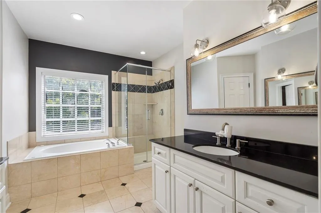 Bathroom featuring a bath, vanity, a stall shower, light tile patterned floors, and recessed lighting Bathroom featuring a bath, vanity, a stall shower, light tile patterned floors, and recessed lighting