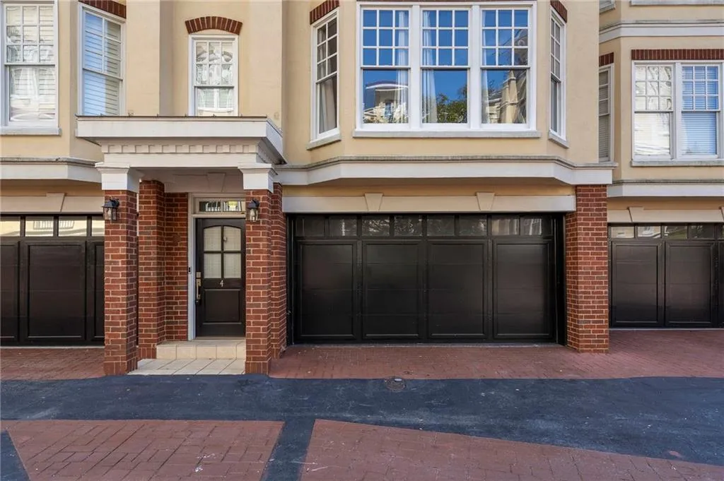 Property entrance featuring brick siding and a garage Property entrance featuring brick siding and a garage
