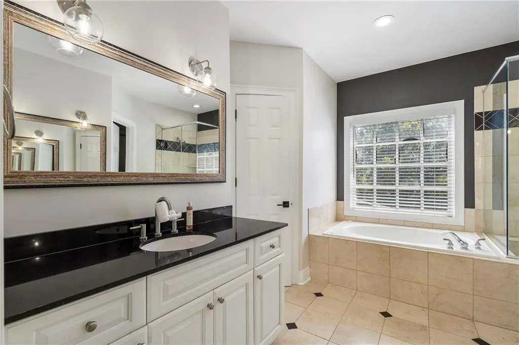 Bathroom featuring vanity, light tile patterned flooring, a garden tub, recessed lighting, and tiled shower Bathroom featuring vanity, light tile patterned flooring, a garden tub, recessed lighting, and tiled shower